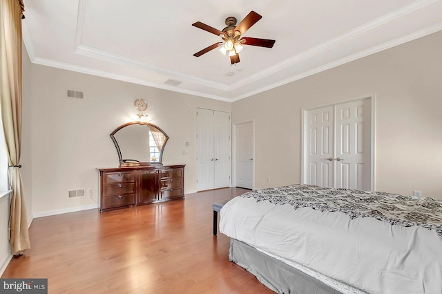 14 Goddard Dr, Cranbury, NJ 08512 - bedroom with light wood-style floors, multiple closets, a raised ceiling, crown molding, and baseboards