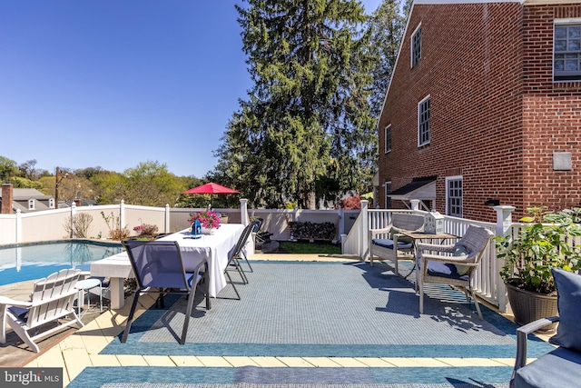 view of swimming pool featuring a fenced backyard, a fenced in pool, and outdoor dining space