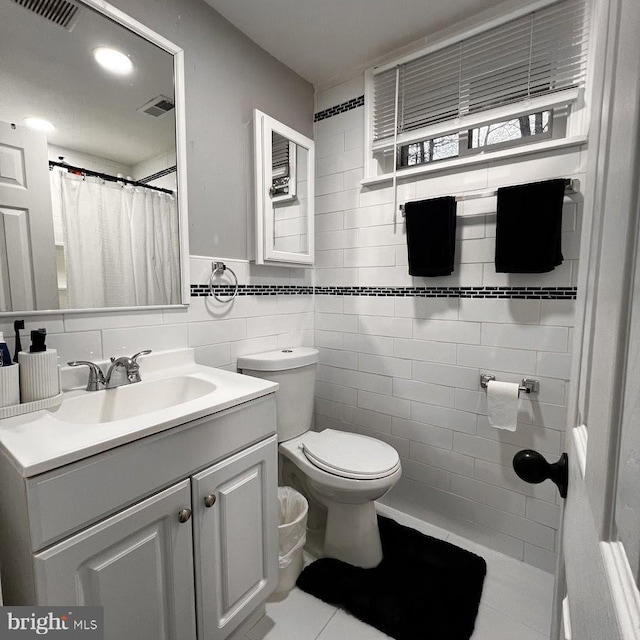 full bathroom with vanity, visible vents, tile walls, and toilet