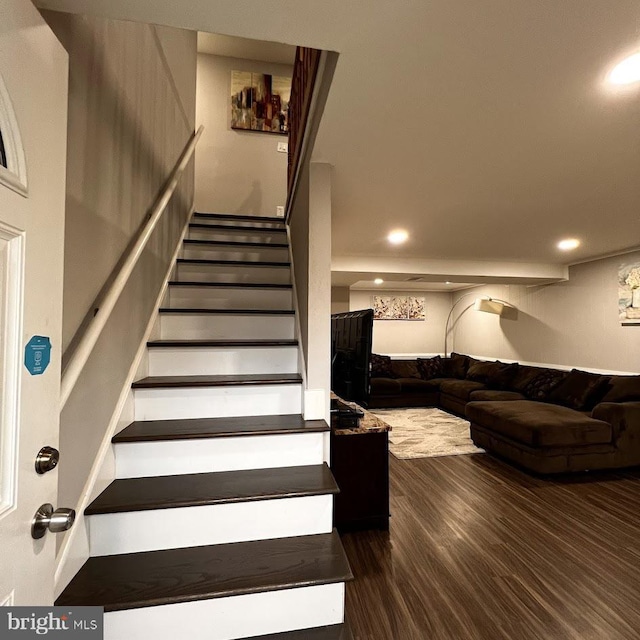 stairs with wood finished floors and recessed lighting
