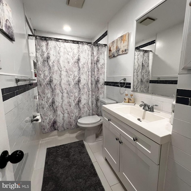 bathroom featuring vanity, visible vents, tile walls, shower / tub combo, and tile patterned floors