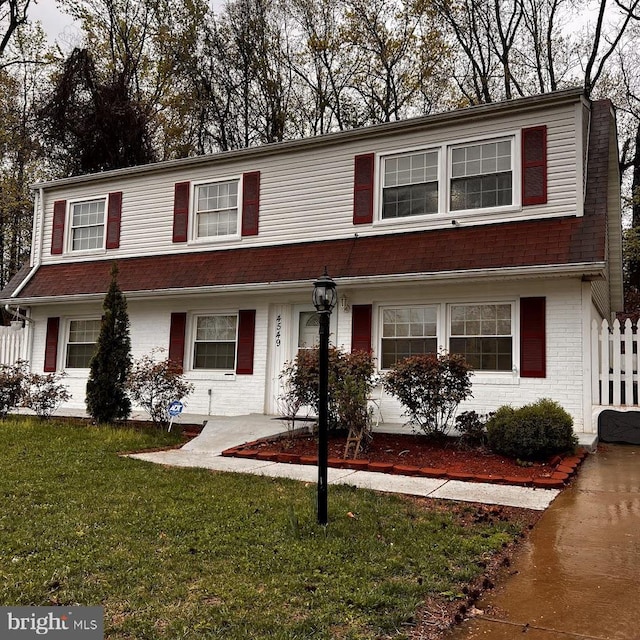 view of front of home featuring brick siding and a front lawn