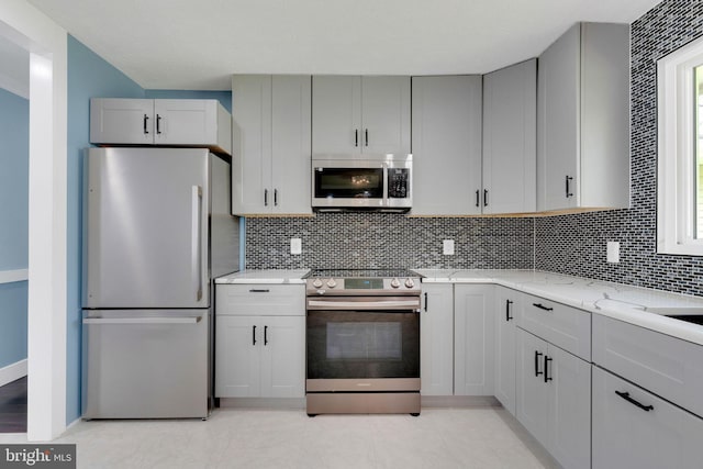 3600 Yorktown Dr, Waldorf, MD 20601 - kitchen with gray cabinets, decorative backsplash, appliances with stainless steel finishes, and light stone countertops