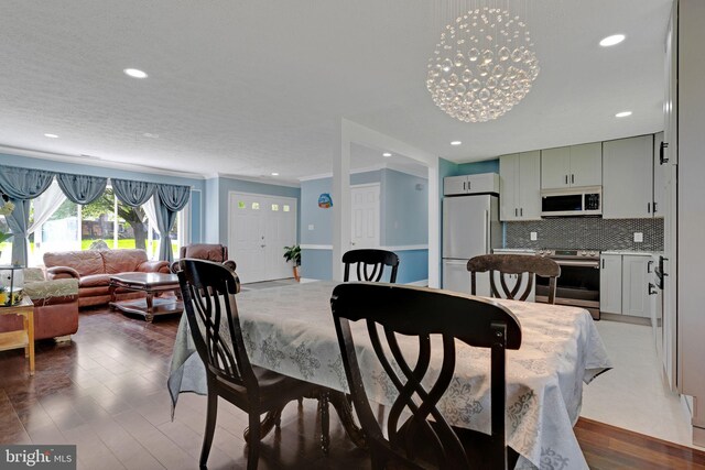 3600 Yorktown Dr, Waldorf, MD 20601 - dining room with wood finished floors, a notable chandelier, ornamental molding, and recessed lighting