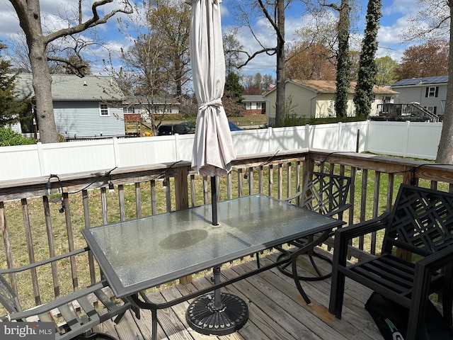 wooden terrace featuring a residential view, a yard, a fenced backyard, and outdoor dining area