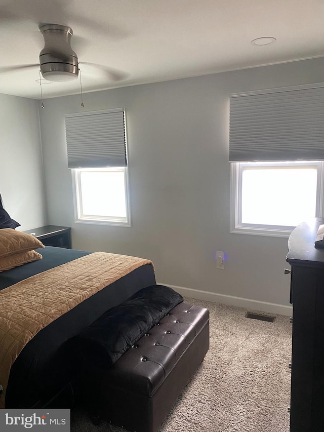 carpeted bedroom with ceiling fan, baseboards, and visible vents