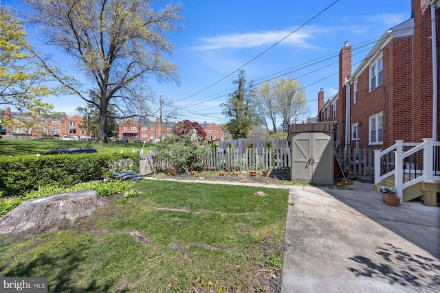 view of yard featuring an outdoor structure, a storage unit, and fence