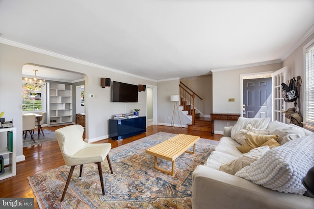 living room featuring wood finished floors, stairs, and ornamental molding