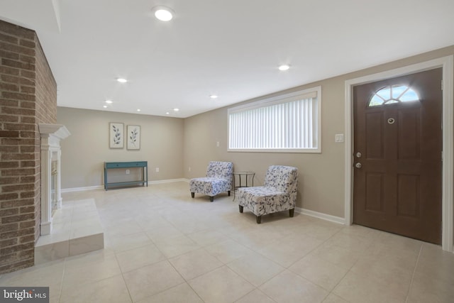 entrance foyer featuring light tile patterned floors, baseboards, a fireplace, and recessed lighting