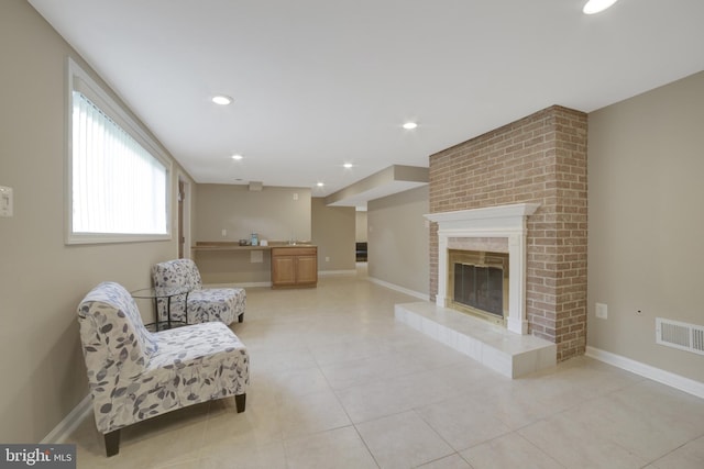 sitting room featuring light tile patterned flooring, a fireplace, baseboards, and recessed lighting