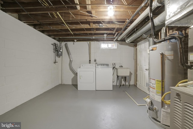 below grade area with washing machine and dryer, gas water heater, a sink, gas meter, and concrete block wall