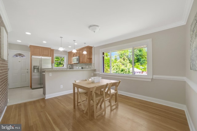dining space with plenty of natural light, light wood-style flooring, crown molding, baseboards, and recessed lighting