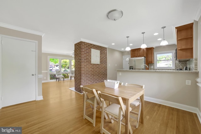 dining space featuring light wood finished floors, recessed lighting, baseboards, and ornamental molding