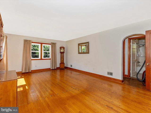 268 Magothy Bridge Rd, Pasadena, MD 21122 - unfurnished living room with arched walkways, baseboards, wood-type flooring, and visible vents