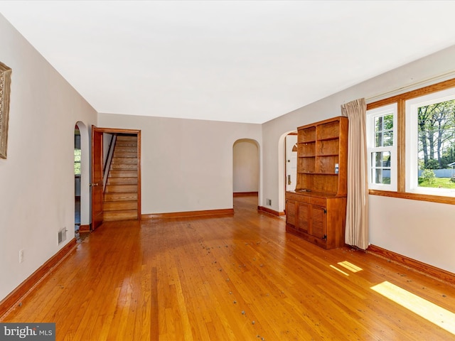 268 Magothy Bridge Rd, Pasadena, MD 21122 - unfurnished living room with arched walkways, baseboards, and light wood-type flooring