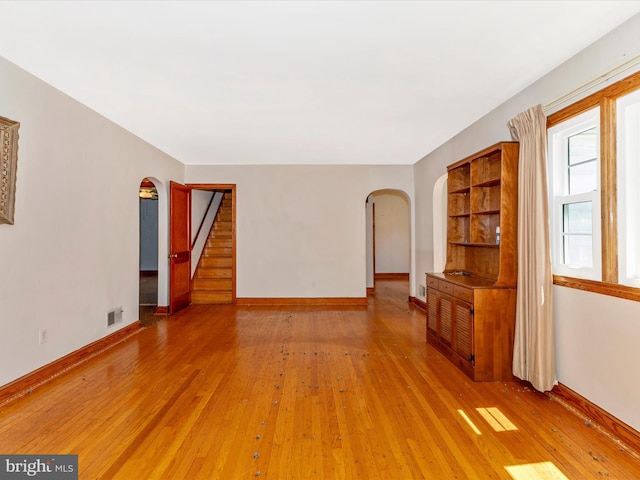 268 Magothy Bridge Rd, Pasadena, MD 21122 - unfurnished living room featuring arched walkways, baseboards, visible vents, and light wood-style flooring