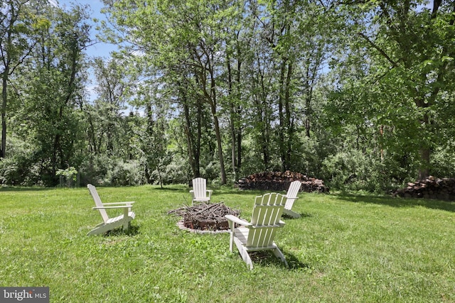 view of grassy yard with a fire pit