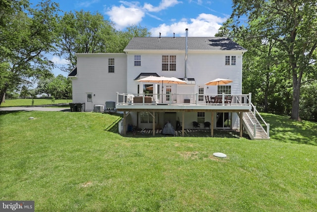 rear view of property featuring stairway, a deck, a lawn, and central air condition unit