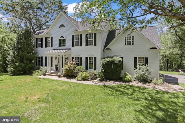 view of front of property with a front lawn and a shingled roof