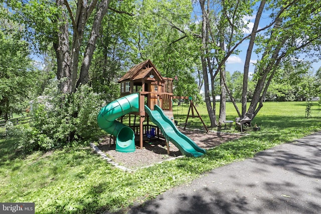community play area featuring a yard and view of wooded area