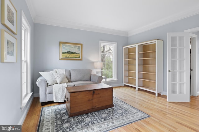 living area featuring ornamental molding, wood finished floors, and baseboards