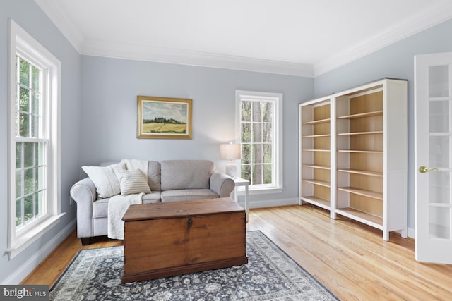 living room featuring healthy amount of natural light, crown molding, wood finished floors, and baseboards