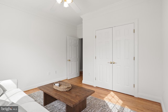 living room with ceiling fan, ornamental molding, light wood-type flooring, and baseboards