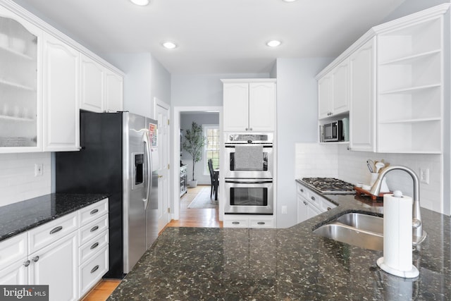 kitchen featuring appliances with stainless steel finishes, white cabinetry, open shelves, glass insert cabinets, and recessed lighting