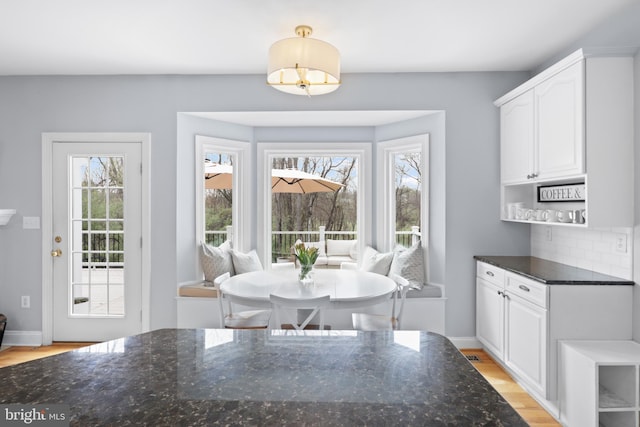dining area featuring light wood finished floors and baseboards