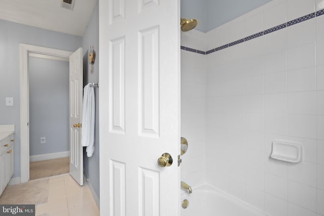 bathroom with washtub / shower combination, vanity, and tile patterned floors