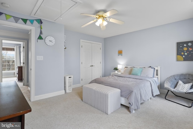 bedroom featuring attic access, light carpet, a closet, baseboards, and a ceiling fan