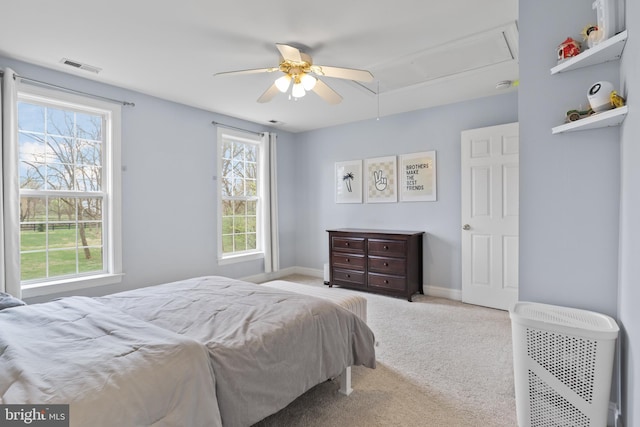 carpeted bedroom with attic access, baseboards, and ceiling fan
