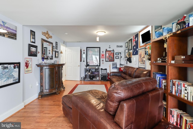 living area with light wood-type flooring and baseboards