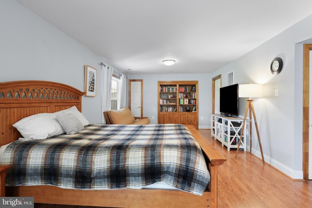bedroom with light wood-type flooring and baseboards