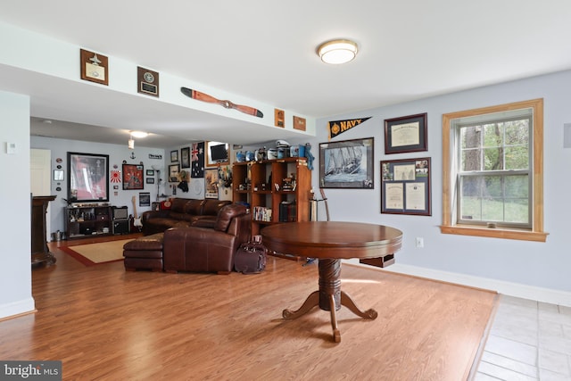 living area with baseboards and wood finished floors