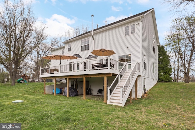 back of house featuring a deck, stairway, a lawn, and a playground