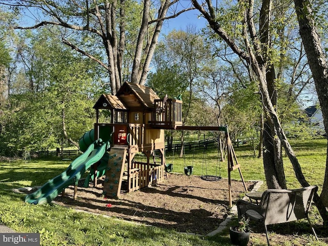 view of jungle gym featuring a lawn and view of scattered trees