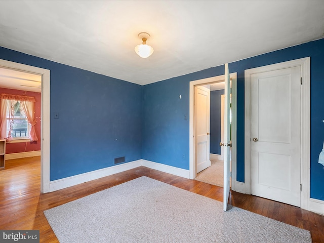unfurnished bedroom featuring baseboards and wood finished floors