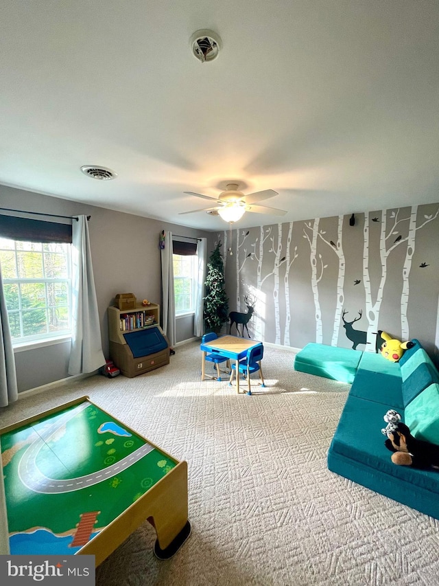 rec room with visible vents, ceiling fan, and carpet