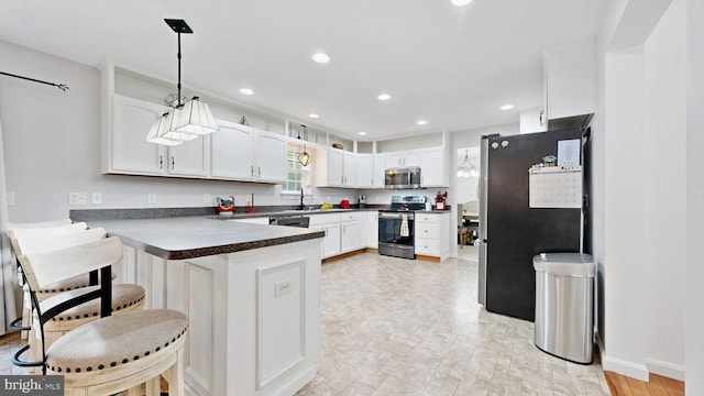 419 Kimberly Way, Felton, DE 19943 - kitchen featuring stainless steel appliances, a peninsula, dark countertops, white cabinets, and hanging light fixtures