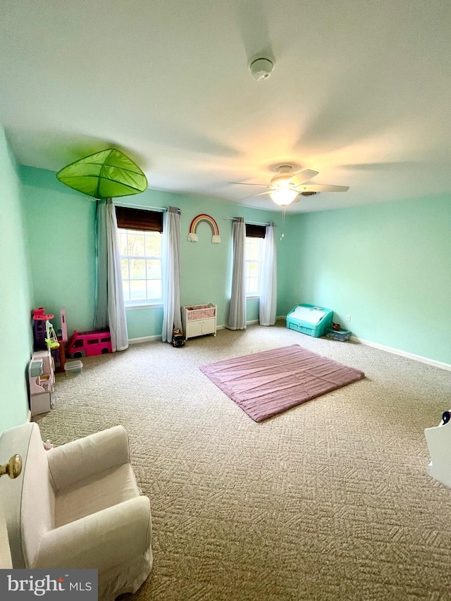 interior space with baseboards, ceiling fan, and carpet floors