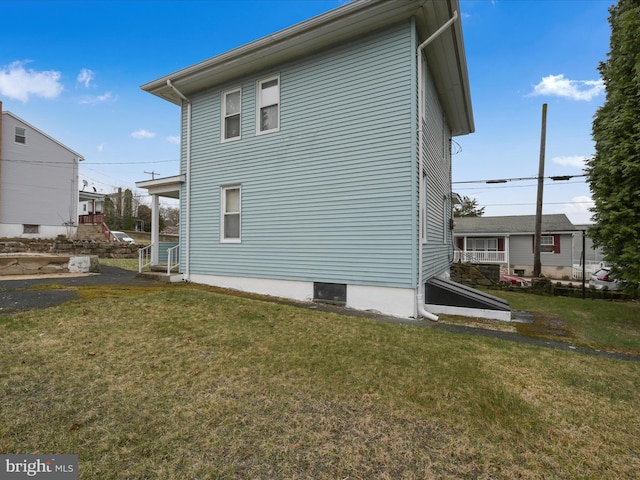 view of side of home with a yard