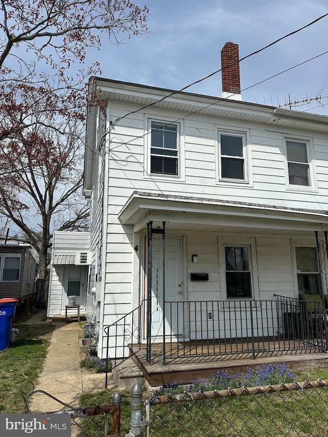 view of front of home with a porch and a chimney