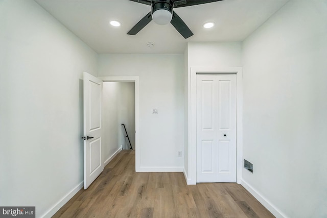 unfurnished bedroom with light wood finished floors, baseboards, and a closet