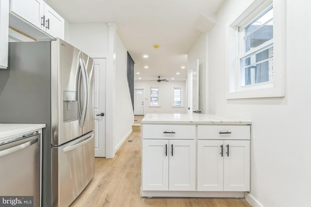 kitchen with a ceiling fan, stainless steel dishwasher, white cabinetry, and light wood-type flooring