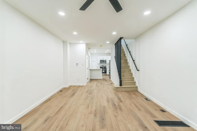 unfurnished living room with light wood-type flooring, visible vents, recessed lighting, a ceiling fan, and stairs