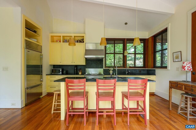 1112 Park St, Charlottesville, VA 22901 - kitchen featuring wall chimney range hood, decorative backsplash, dark countertops, and built in fridge