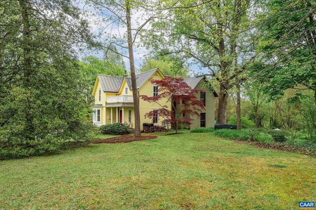 1112 Park St, Charlottesville, VA 22901 - view of front of home featuring a standing seam roof, a balcony, a front yard, and metal roof