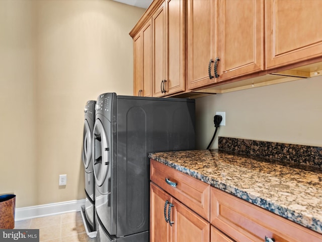 laundry area with light tile patterned flooring, independent washer and dryer, baseboards, and cabinet space