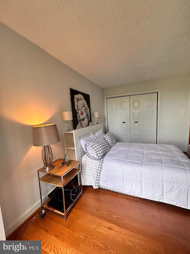 2300 Pimmit Dr Unit 601, Falls Church, VA 22043 - bedroom featuring a closet, wood finished floors, a textured ceiling, and baseboards